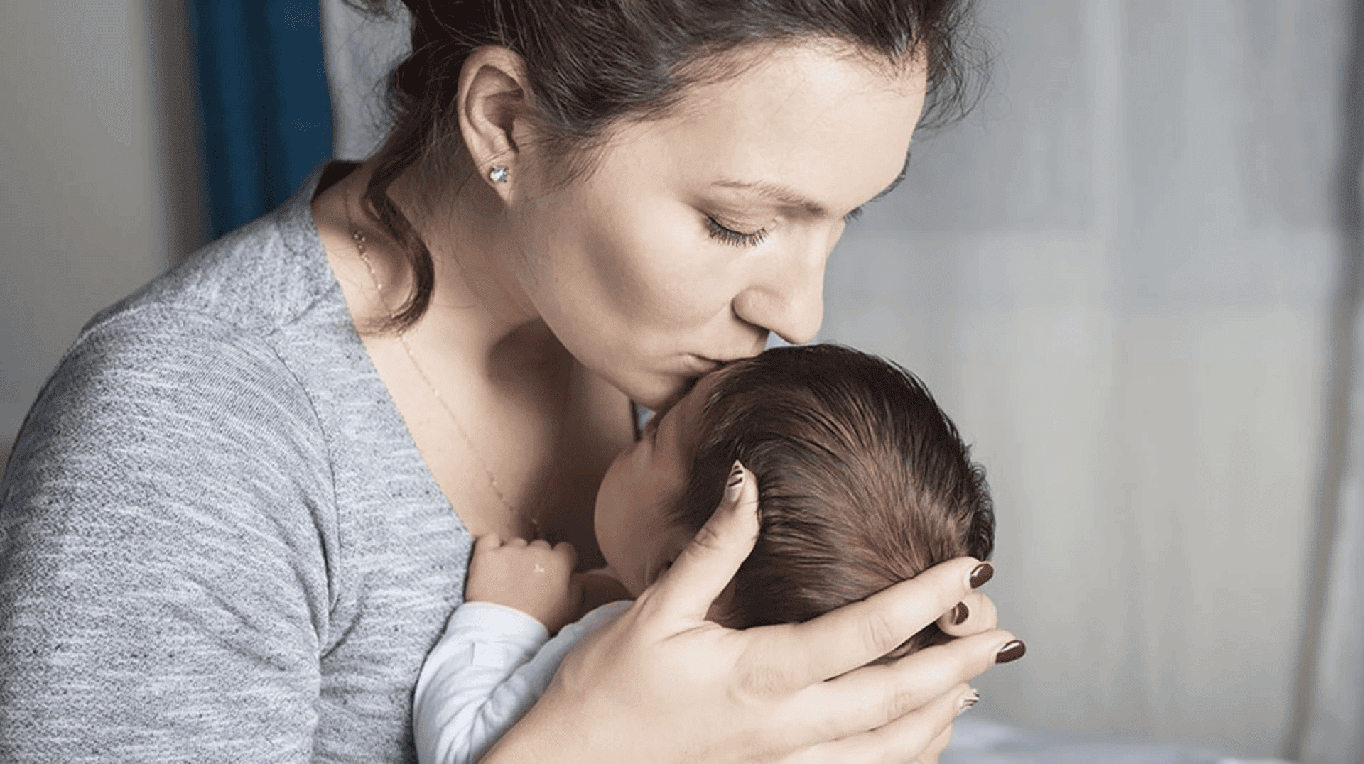 mum-kissing-newborn-on-forehead